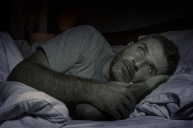 Gece karanlığında çekici bir portre. Depresyonda ve endişeli bir adam. Depresyon ve endişe içinde uykusuzluk ve uykusuzluk yüzünden uykusuzluk hissi.
