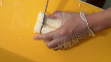 Asyalı profesyonel aşçının elleri restoran mutfağında lezzetli ve sağlıklı Japon suşi dürümleri hazırlıyor. Güzel malzemelerle geleneksel Japon yemekleri yapıyor.