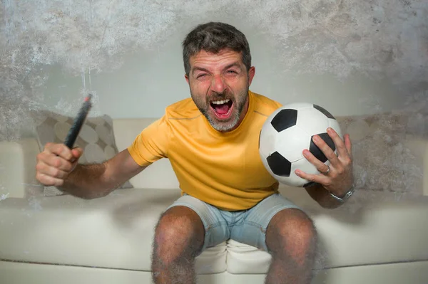 在客厅沙发上看电视足球比赛的年轻 快乐的足球支持者庆祝球队进球进球时情绪激昂尖叫 — 图库照片
