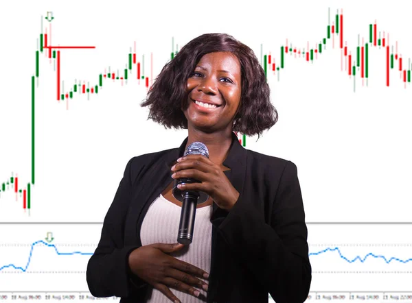 株式と外国為替市場取引の成功 若い美しく幸せなアフロアメリカのビジネス女性とトレーダーのコーチング投資戦略とキャンドルスティックグラフ上の財務上の成功 — ストック写真