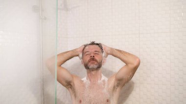 Sabah duşu. Sakallı, genç ve mutlu bir adamın hayat tarzı. Evde duş alıyor, saçını şampuanla yıkıyor.