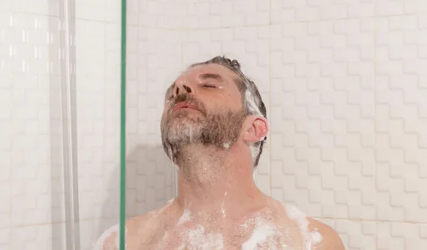 清晨淋浴 年轻迷人而快乐的留着胡子的男人在家里洗澡用洗发水洗头 享受健康和卫生概念的快乐的生活方式画像 — 图库照片