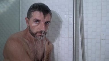 Evde banyo dramatik bir şekilde genç, çekici, üzgün ve depresif bir adamın duşta duvara yaslanmış düşünceli bir şekilde hayat sorununun altında ezildiği bir sahne. 