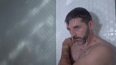 Evde banyo dramatik bir şekilde genç, çekici, üzgün ve depresif bir adamın duşta duvara yaslanmış düşünceli bir şekilde hayat sorununun altında ezildiği bir sahne. 