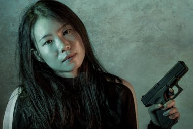 Çekici ve tehlikeli bir kadın ajanın ya da elinde tabanca olan Asyalı bir gangsterin, Hollywood film tarzında ateşli bir şekilde silahını doğrultmuş sinemalı bir portresi.