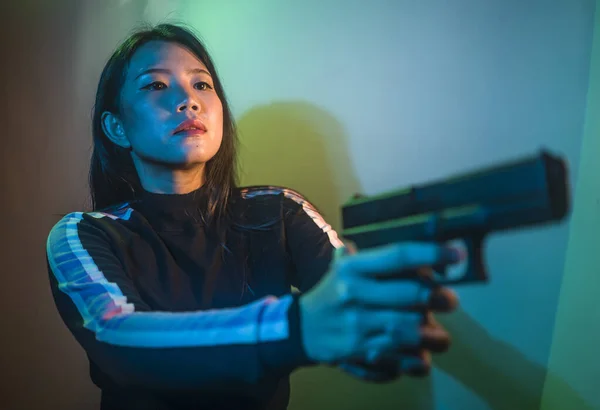 cinematic portrait of young attractive and dangerous special agent woman spy or Asian Korean mobster girl holding handgun pointing the gun fierce in Hollywood movie style