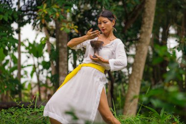Zihin ve beden bağlantısı - güzel ve mutlu şifacı Asyalı kadın tütsü bardağı tutuyor yeşil tropikal ormanda geleneksel iyileştirme dansı yapıyor sağlıklı ve sağlıklı yaşam tarzı 
