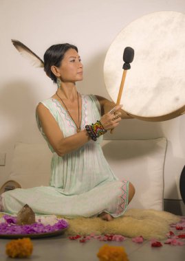 ses iyileştirme ve meditasyon terapisi - çekici ve zarif Asyalı Çinli şifacı kadın yoga stüdyosunda rahatlama egzersizi ve sağlıklı yaşam tarzı olarak davul çalıyor.