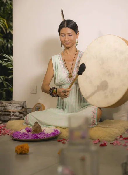 sound healing and meditation therapy - attractive and elegant Asian Chinese healer woman playing drum at yoga studio as relaxation exercise in wellness and healthy lifestyle