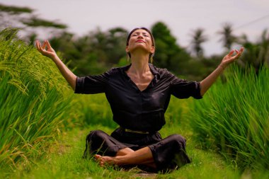 Pirinç tarlasında açık havada yoga ve meditasyon - çekici ve mutlu orta yaşlı Asyalı Çinli kadın sağlıklı yaşam tarzı ve sağlıkla ilgili olarak yoga ve rahatlamanın tadını çıkarıyor.
