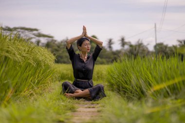 Pirinç tarlasında açık havada yoga ve meditasyon - çekici ve mutlu orta yaşlı Asyalı Japon kadın sağlıklı yaşam tarzı ve sağlıkla bağlantılı olarak yoga ve rahatlamanın tadını çıkarıyor.