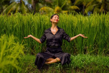 Pirinç tarlasında açık havada yoga ve meditasyon - çekici ve mutlu orta yaşlı Asyalı Japon kadın sağlıklı yaşam tarzı ve sağlıkla bağlantılı olarak yoga ve rahatlamanın tadını çıkarıyor.