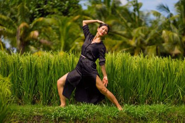 Pirinç tarlasında açık havada yoga ve meditasyon - çekici ve mutlu orta yaşlı Asyalı Japon kadın sağlıklı yaşam tarzı ve sağlıkla bağlantılı olarak yoga ve rahatlamanın tadını çıkarıyor.