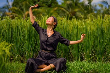 Pirinç tarlasında açık havada yoga ve meditasyon - çekici ve mutlu orta yaşlı Asyalı Koreli kadın sağlıklı yaşam tarzı ve sağlıkla ilgili olarak yoga ve rahatlıktan zevk alıyor.
