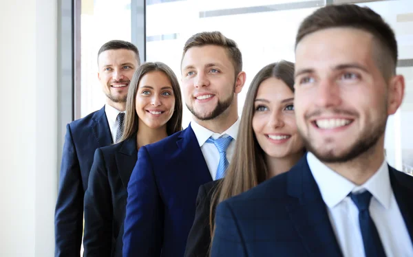 Gelukkig lachend zakelijke team staan in een rij op kantoor — Stockfoto