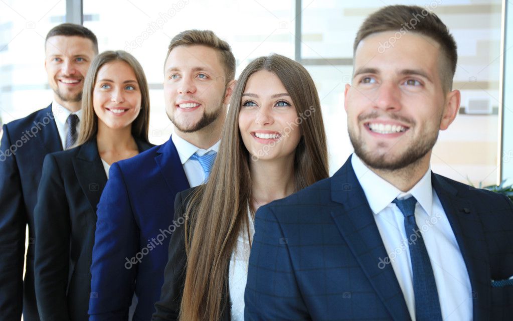 Happy smiling business team standing in a row at office