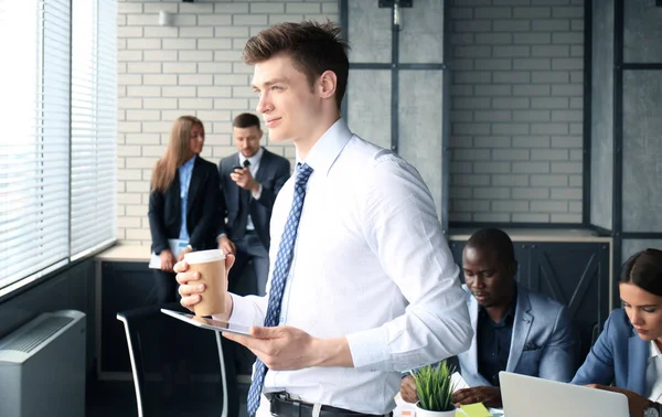 Młody biznesmen stoi w biurze — Zdjęcie stockowe