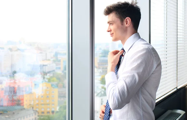 Knappe zakenman die door het raam kijkt — Stockfoto