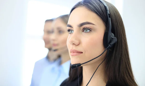 Retrato da funcionária do call center acompanhada por sua equipe. Smiling operador de suporte ao cliente no trabalho. — Fotografia de Stock