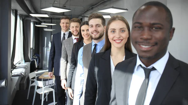 Feliz equipo de negocios sonriente de pie en una fila en la oficina . —  Fotos de Stock