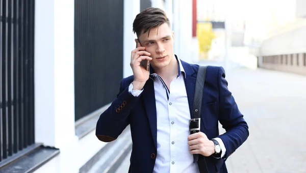 Joven empresario urbano profesional en smartphone caminando por la calle usando teléfono móvil . — Foto de Stock