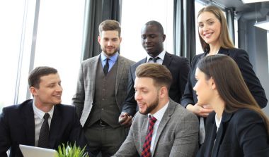 Beyin fırtınası. Birlikte laptop arıyorum iş adamları grubu. Kameraya bakarak bir iş kadını.