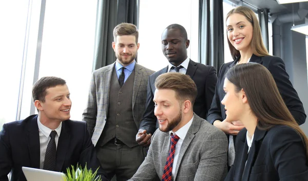 Brainstorm. Groep van mensen uit het bedrijfsleven samen te kijken naar de laptop. Een zakenvrouw camera kijken. — Stockfoto