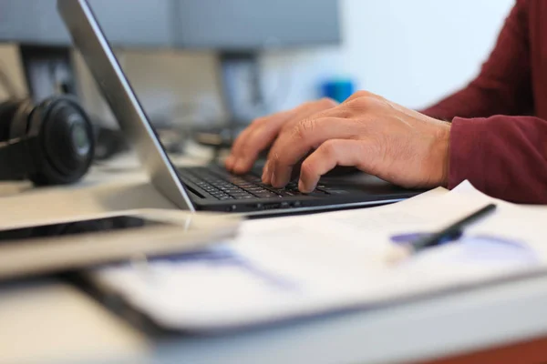 Hombre joven que trabaja con el ordenador portátil, persona de negocios en el lugar de trabajo . — Foto de Stock