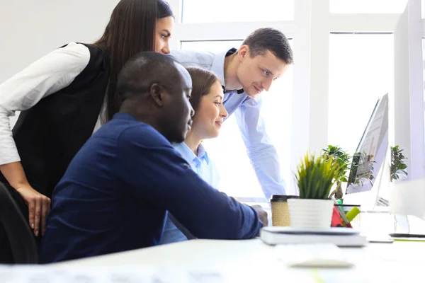 Equipo de colegas haciendo una lluvia de ideas mientras trabajan en la computadora. — Foto de Stock