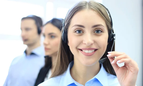 Porträtt av callcenter arbetare tillsammans med hennes team. Leende kundsupportoperatör på jobbet. — Stockfoto