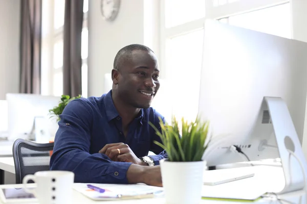 Retrato de un empresario afroamericano feliz mostrando un ordenador en la oficina . —  Fotos de Stock