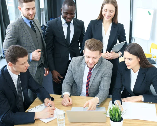 Brainstorm. Groep van mensen uit het bedrijfsleven samen te kijken naar de laptop. Een zakenvrouw camera kijken. — Stockfoto