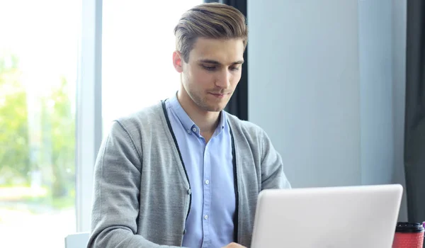 Jeune homme d'affaires travaillant avec un ordinateur portable au bureau. — Photo