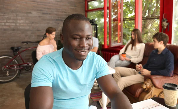 Portret van een gelukkig Afro-Amerikaanse ondernemer computer weergeven in office. — Stockfoto