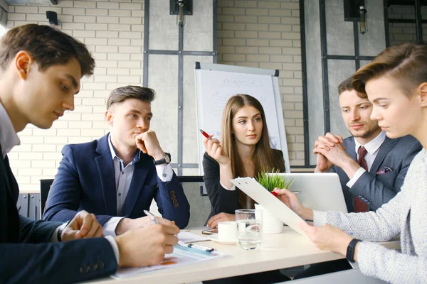 Brainstorm. Grupa ludzi biznesu, patrząc na laptopa ze sobą. Jeden biznes kobieta patrząc na kamery. — Zdjęcie stockowe