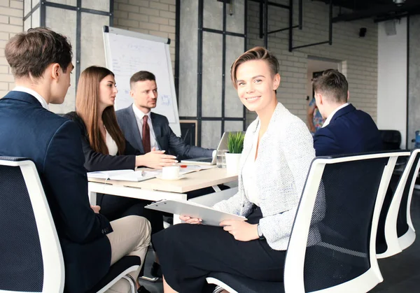 Mujer de negocios con su personal, el grupo de personas en segundo plano en la oficina brillante moderna en el interior. — Foto de Stock