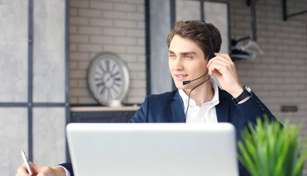 Lachend vriendelijke knappe jonge mannelijke call center operator. — Stockfoto