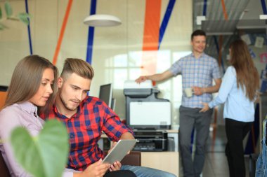 Touchpad arka planda çalışan kendi meslektaşları süre bakarak iki kendine güvenen gençlerin.