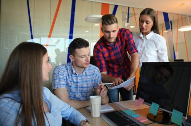 Smart casual modern gençlerin grup giymek bir beyin fırtınası dururken yaratıcı ofiste toplantısı.