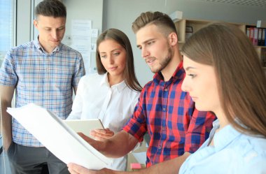 Smart casual modern gençlerin grup giymek bir beyin fırtınası dururken yaratıcı ofiste toplantısı.