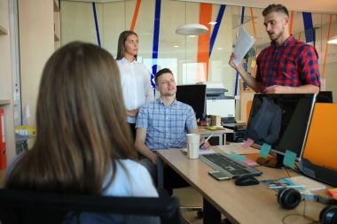 Smart casual modern gençlerin grup giymek bir beyin fırtınası dururken yaratıcı ofiste toplantısı.