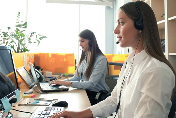 Atraktivní pozitivní mladí podnikatelé a kolegové v call centru. — Stock fotografie