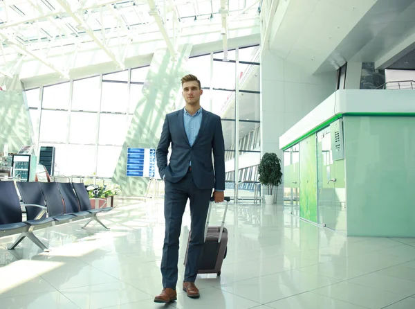 Homem de negócios com mala no hall do aeroporto . — Fotografia de Stock