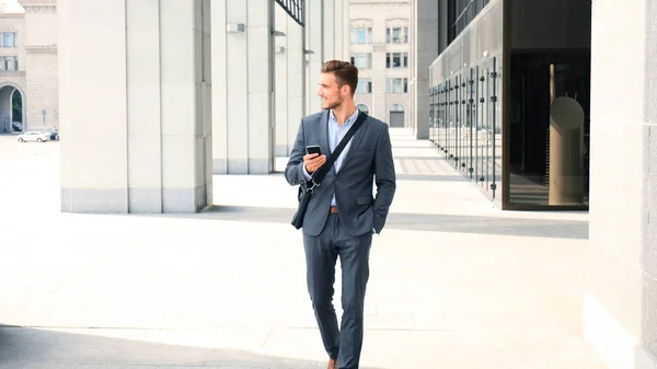 Jonge stedelijke zakenman professional op smartphone wandelen in de straat via mobiele telefoon. — Stockfoto