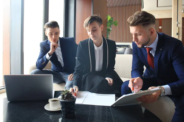 Girişim ekibi, modern parlak ofis içi beyin fırtınası, dizüstü bilgisayar ve tablet bilgisayar üzerine toplantı üzerine çalışıyor.