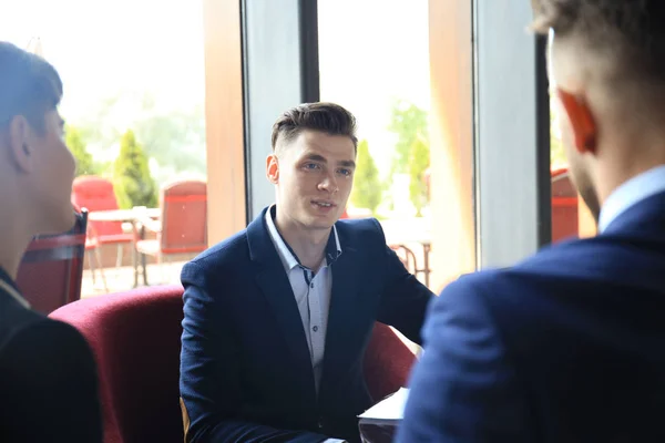 Hombre de negocios inteligente feliz con compañeros de equipo discutiendo . — Foto de Stock