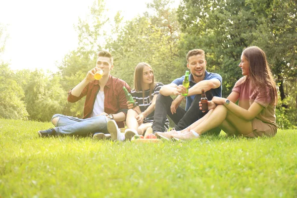 Happy mladí přátelé užívat piknik a jíst. — Stock fotografie