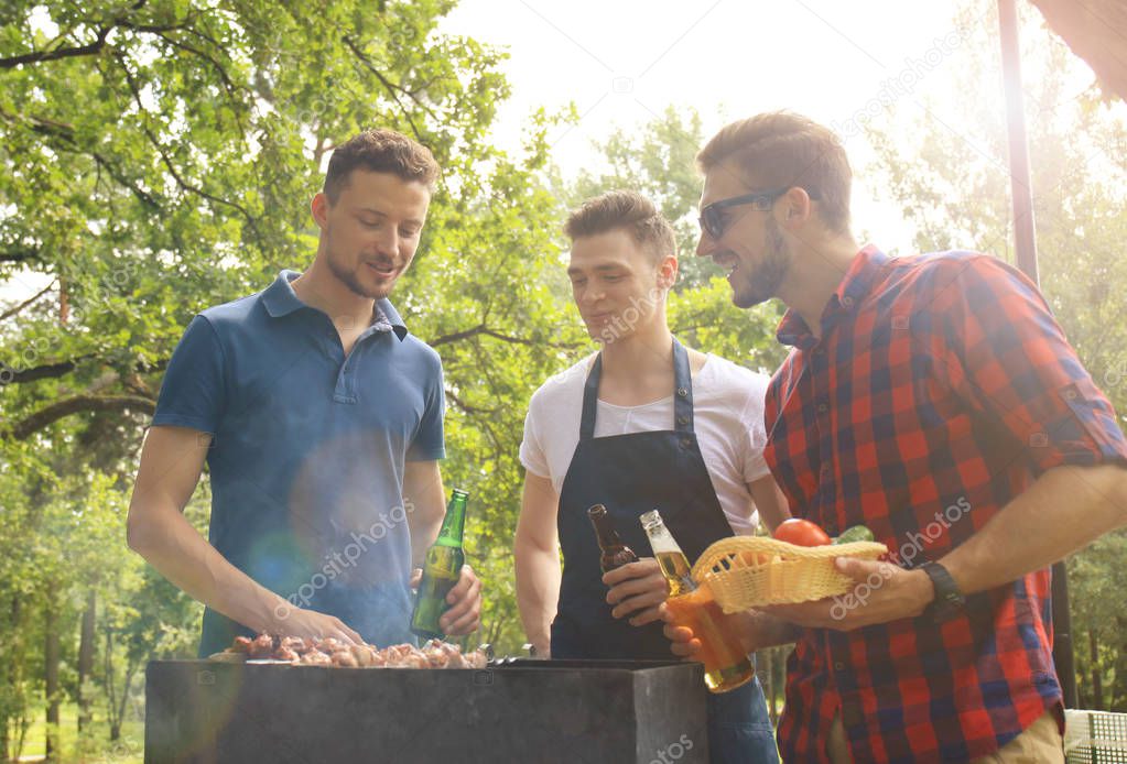 Friends spending time in nature and having barbecue.