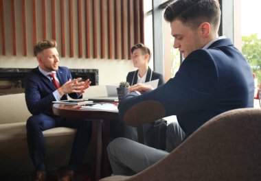 İş adamı onun kol saati zaman kontrol görünüyor. Bir Toplantı oturma ve çalışma vasıl geçmiş işadamı.