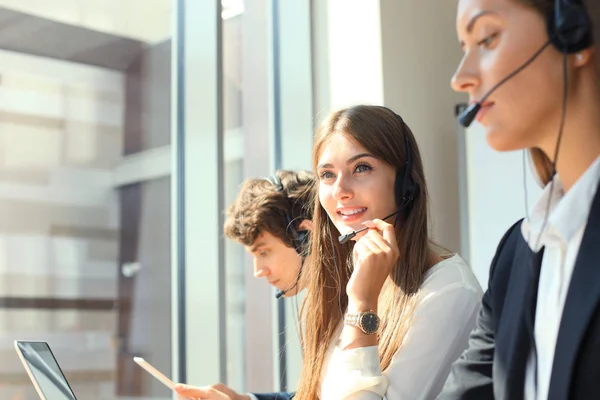 Atractivos jóvenes empresarios y colegas positivos en una oficina de call center. —  Fotos de Stock